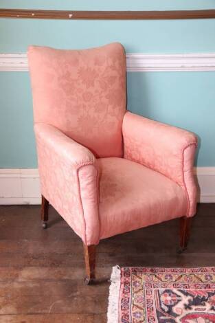 A Edwardian mahogany armchair, upholstered in coral damask fabric on square tapering legs with castors.