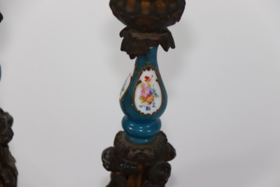 A pair of late 19thC ormolu figural candlesticks, with urn shaped sconces (one lacking) and holders with porcelain baluster columns, painted with reserves of flowers, on a blue ground, raised above three standing putti, on stepped circular bases with acan - 2