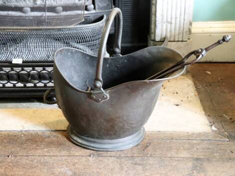 A Victorian copper coal helmet, and a pair of tongs, 45cm.