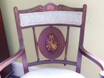 An Edwardian mahogany and marquetry open armchair, with a padded back and seat inlaid with musical trophies, shells, flowers, etc., on square tapering legs with ceramic castors. - 2