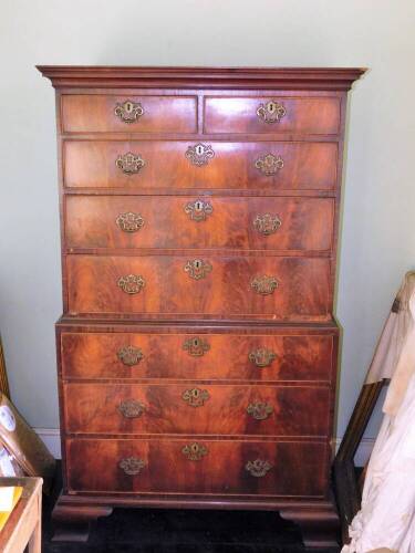 A George III mahogany chest on chest, the top with a moulded cornice above two short and three long drawers, the base with three further long drawers, each with pierced brass handles and escutcheons on ogee bracket feet, 170cm high, 107cm wide, 56cm deep.