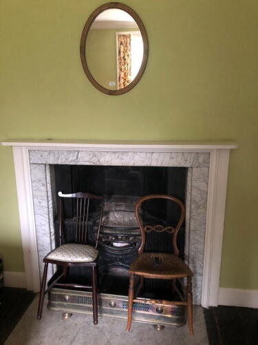 A gilt gesso oval wall mirror, with a moulded frame, 54cm x 44cm, a Victorian balloon back bedroom chair, another bedroom chair and a polished steel fender, 103cm wide.