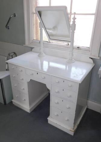 A Victorian painted dressing table, the rectangular plate on turned supports, the kneehole base with a moulded edge and an arrangement of nine drawers on a plinth base, 106cm wide.