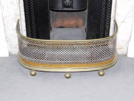 A late 19thC small brass and mesh nursery fender, of bowed form with bun feet, 25cm high, 59cm wide.