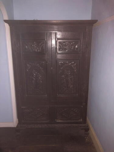 A 17thC and later carved oak two-door cupboard, with moulded cornice, two carved panel doors revealing a full length hanging interior over a two panel base, on ogee bracket feet, 182cm high, 126cm wide, 53cm deep.