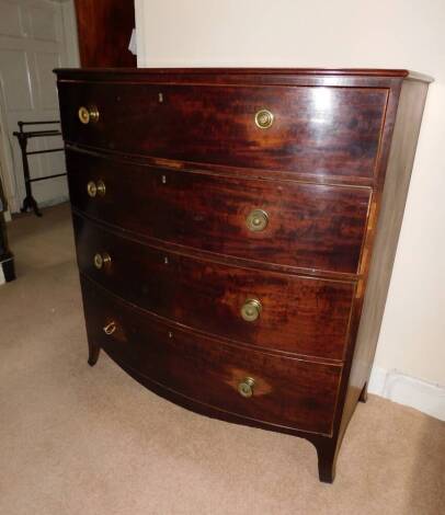 A Regency mahogany bowfront chest of drawers, with a plain top above four drawers, each with pressed gilt metal handles on splayed feet, 125cm high, 115cm wide, 59.5cm deep.