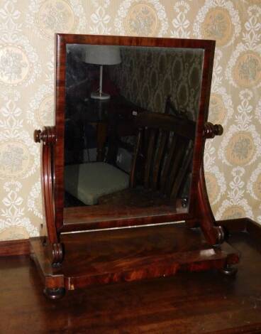 A Victorian flamed mahogany swing framed dressing table mirror, with a rectangular plate, scroll supports, shaped platform base with inset corners, on bun feet, 66cm high, 56cm wide.