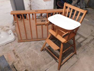 A folding wooden cot and child's high chair. (2)