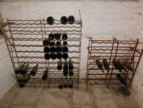 Two wrought iron wine racks, the left 144 bottle, the right 64 bottle.