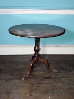 An early 19thC oak occasional table, the circular planked tilt top on a turned column and a tripod base with pad feet, 71cm high, 83cm diameter.