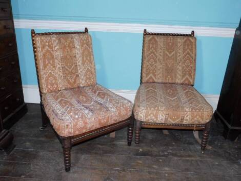 A pair of early Victorian rosewood bobbin turned sidechairs, each with a loose fitted padded cushion, on tapering legs and brass castors. (AF)