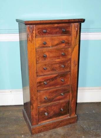 A William IV rosewood Wellington chest, with a plain top above seven graduated drawers each with turned wood handles flanked by plain leaf capped pilasters, one hinged as a retainer on plinth base, 110cm high, 52cm wide, 36cm deep.