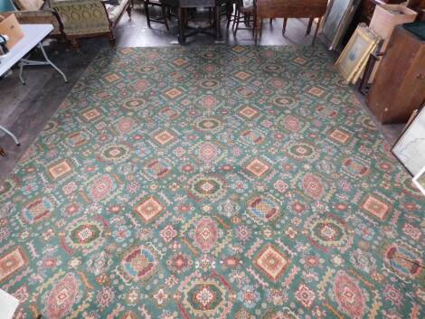 A large Axminster type carpet, with the design of medallions on a green ground, 236cm x 462cm.