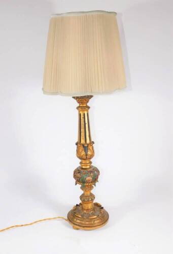 A carved giltwood table lamp, of classical design with fluted tapered balaster column, carved with a collar of flowers, on a circular base, and the shade, 46cm high.