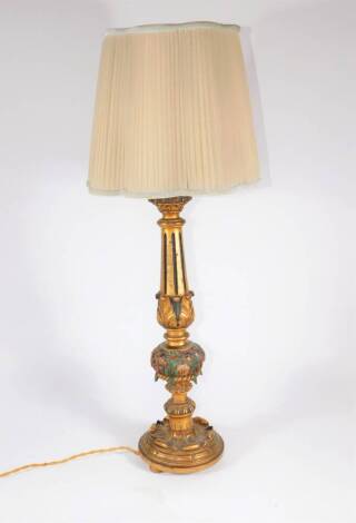 A carved giltwood table lamp, of classical design with fluted tapered balaster column, carved with a collar of flowers, on a circular base, and the shade, 46cm high.