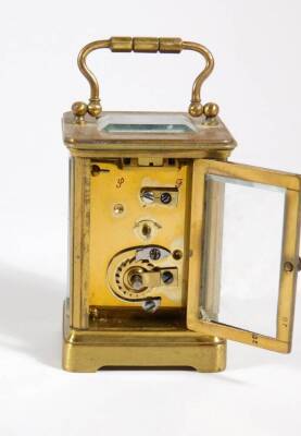 A late Victorian brass cased carriage clock, the enamelled chapter ring with Arabic numerals, visible escapement, 10cm high (handle up), and the red leather travelling case, with key. - 4