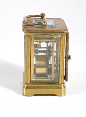 A late Victorian brass cased carriage clock, the enamelled chapter ring with Arabic numerals, visible escapement, 10cm high (handle up), and the red leather travelling case, with key. - 6