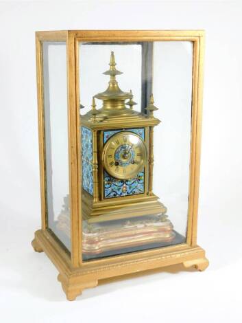 A 19thC French gilt brass and champleve enamel mantel clock, with eight day movement impressed Chles MT 26104, 30cm high plus stand and glazed cabinet. (3)