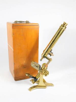 A 19thC brass monocular microscope, with single eyepiece and two objective lenses, in a fitted pine case with brass handle, 35cm high at lowest setting.