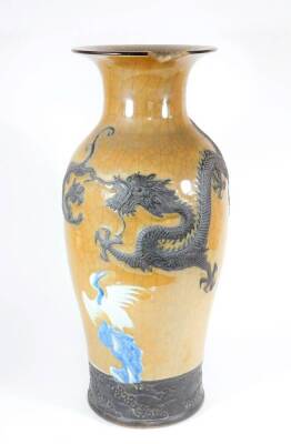 A 19thC Chinese crackle ware baluster vase, with raised blue and white scenic decoration with figures over a brown ground and having four celestial dragon in relief and cloud banded base, seal mark to base, 57cm high. (Af-loss to rim)