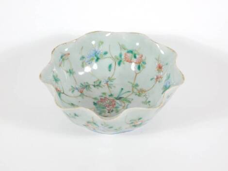 A 19thC celadon glazed Chinese porcelain bowl enamelled with peony branches, with wavy edge and six character Tongzhi seal mark to base and probably of the period (1862 - 1874), 17cm diameter.