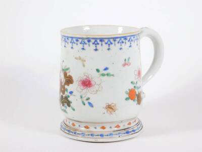 An 18thC Chinese porcelain baluster tankard, painted in enamels with peonies and fruit, 15cm high. (AF - repaired handle)