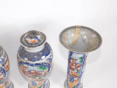 A group of four 18th/19thC Chinese famille rose and blue and white porcelain vases, comprising three baluster vases with covers and a flared beaker vase with similar court scenes and reservoirs in polychrome colours, 18cm high. (AF - various losses and re - 3