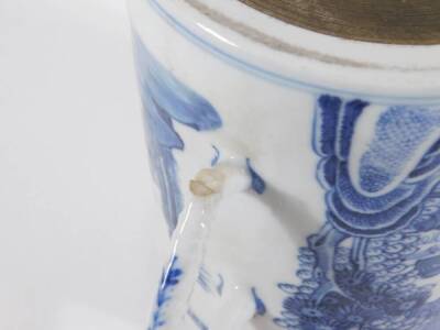 An early 19thC Chinese blue and white porcelain pallet mug, handpainted with landscape, boats, figures, and pagodas, 14cm high. (AF - loss to foot of handle, two chips to the rim) - 6