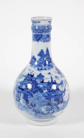 An early 19thC Chinese blue and white porcelain bottle vase, with diaper work neck and extensive landscapes with pagodas, buildings and two figures crossing a bridge, 23cm high.