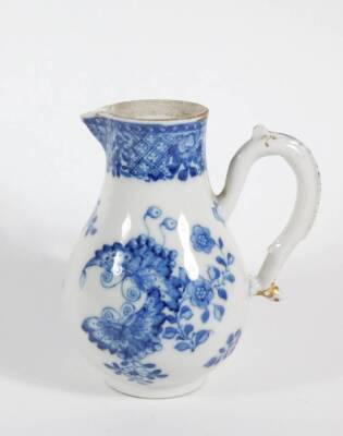 An early 19thC Chinese blue and white porcelain milk jug, with loop handle and sparrow beak spout, decorated with butterflies and flora, 14cm high.