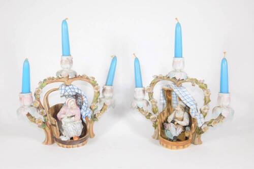 A pair of 19thC Dresden porcelain figural candelabra, each with three sconces and a central basket modelled with figures of an elderly lady and gentleman in barrels with arching bocage branches, underglaze blue cross swords mark to base, 26cm high.