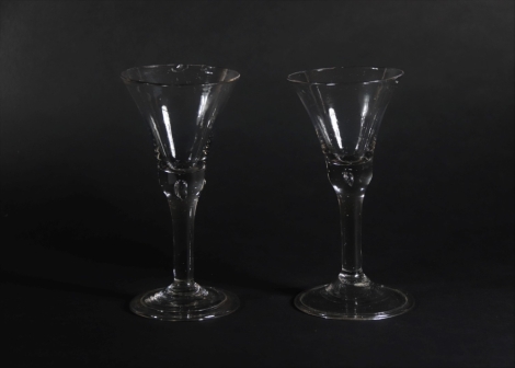 An 18thC wine glass, with thistle bowl and solid air base, with tapered stem and folded foot, 17cm high and another similar glass. (2)