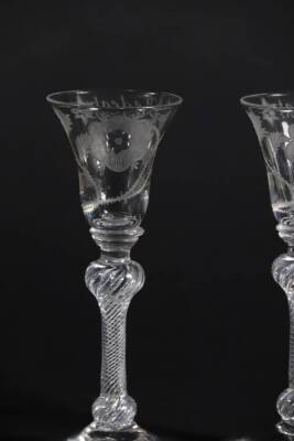 A pair of mid 18thC Jacobite wine glasses, with engraved thistle bowls, each having a white rose and buds and inscribed 'Redeat' with a star, on double knopped air twist stems, 14.7cm and 15cm high. - 4