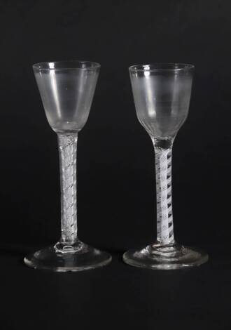 An 18thC wine glass, with fluted ogee bowl and double opaque twisted stem, 15.5cm high and an 18thC wine glass with plain round funnel bowl and double air twist stem, 15.8cm long, (2).