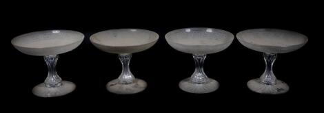 A set of four Victorian glass tazzae, with shallow frosted bowls having Greek Key borders, supported on cut and waisted stems and circular feet, with petal cut bases, 15cm high, 19cm diameter.