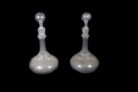 A pair of Victorian cut glass decanters, with slender tapered and collared necks, and plain compressed spherical bodies, having cut spherical stoppers, 30cm high.