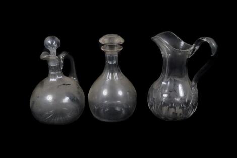 A Victorian glass decanter, with slice cut neck and faceted mushroom stopper, 23cm high., a Victorian glass ewer, with slice cut neck, star cut base and plain stopper, and a Victorian water jug with slice cut neck and body, 27cm high. (3)