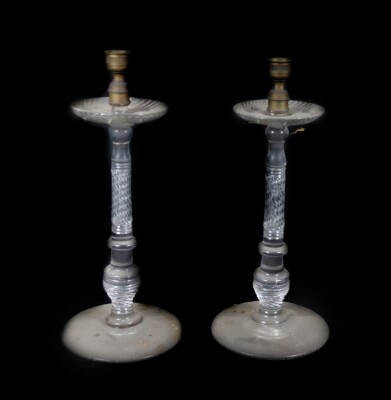 A pair of early 19thC glass candlesticks, with brass sconces and broad cut drip pans, supported on slender knopped and spiral cut stems, with whorl fluted bases, and raised upon slightly domed circular feet with undercut borders, lacking hanging lustre dr