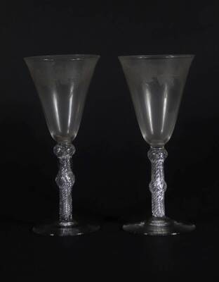 A pair of early 19thC wine glasses with trumpet shaped bowls, each engraved with a band of fruiting vine decoration, on double knopped air twist stems, and plain circular feet, 18.5cm high.