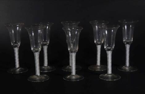 A set of eight 18thC wine glasses, with plain trumpet shaped bowls, on double opaque twist stems and plain circular feet, the tallest glass measures 16cm high.