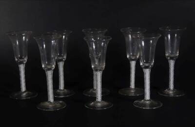 A set of eight 18thC wine glasses, with plain trumpet shaped bowls, on double opaque twist stems and plain circular feet, the tallest glass measures 16cm high.