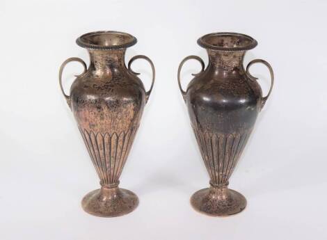 A pair of Late Victorian silver slender urn shaped vases, with everted gadrooned borders and tapered fluted bodies with two handles, raised on plain tapered circular feet, 27cm high, Sheffield 1901, 36oz.