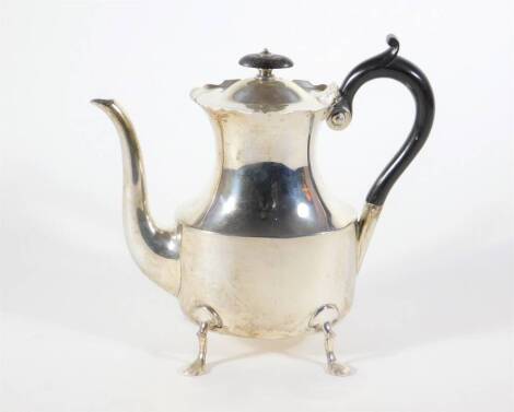 A late Victorian silver coffee pot, with everted wavey border and waisted oval body with query handle, raised on four stylized feet, London 1900, makers: Goldsmiths and Silversmiths Company Ltd, 18.5oz all in.