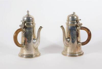 A pair of Edwardian silver chocolate pots, reproduced in the early Georgian manner with hinged lids, tapered bodies and octagonal tapered spouts, London 1907, makers: Alexander Clarke & Co, 18cm high, 18oz all in.