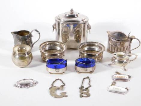 A silver plated oval tea canister, with lions ring handles, a pair of small silver plated coasters, decanter labels, condiment pieces, etc. NB. Please note that the two illustrated small oval salts with high blue glass liners have been withdrawn from the