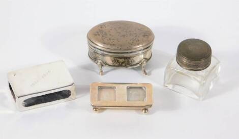 A late Victorian silver stamp case, Birmingham 1900, silver oval jewellery box, silver match box cover, and a square glass ink receiver. (4)