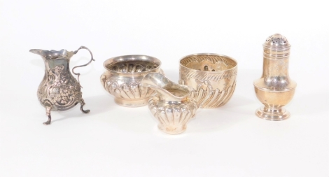 A late Victorian silver sugar bowl, of fluted design, London 1900, another Victorian silver sugar bowl, London 1890, two silver cream jugs and a crested silver sugar castor, 14.6oz. (5)