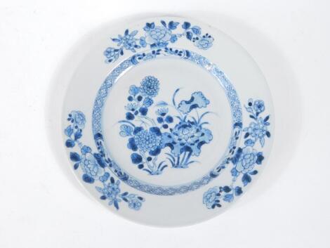 A 18thC Chinese blue and white plate, decorated with a floral landscape, 23cm diameter.