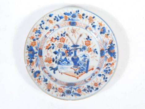 A 18thC Chinese plate, polychrome decorated with a vase, table and flowers, 23cm diameter.