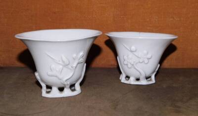 A pair of 18th/19thC Chinese Blanc De Chine libation cups, moulded with open work naturalistic bases, 7cm high. (1 AF) - 2